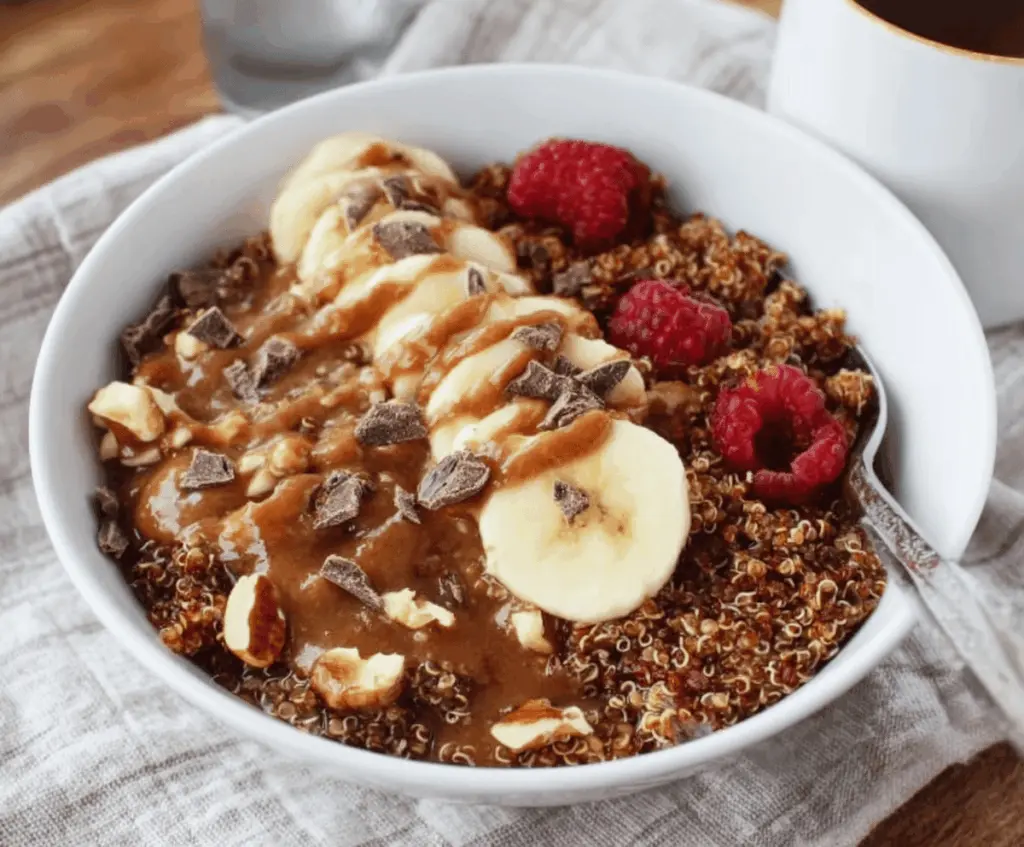 Healthy Chunky Monkey Quinoa Breakfast Bowl with banana slices, walnuts, chocolate chips, and creamy yogurt in a bowl, perfect for a nutritious start to your day.