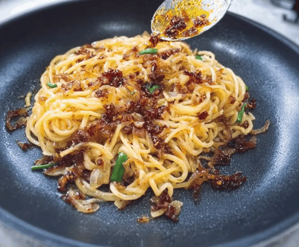 Delicious caramelized onion pasta drizzled with spicy chili oil, perfect for a flavorful meal.