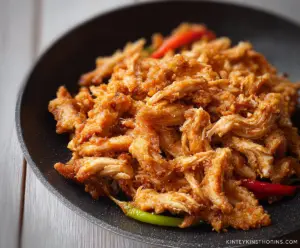 Delicious crispy shredded chicken served with dipping sauces on a wooden platter.