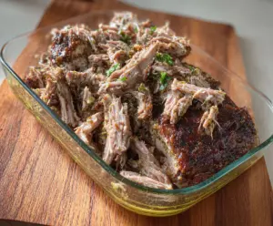 Delicious Mojito Pulled Pork served with fresh herbs and lime slices.