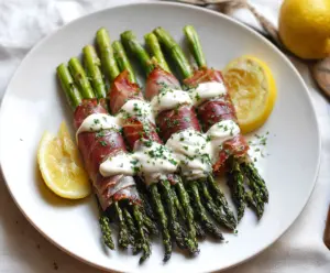 Delicious prosciutto-wrapped asparagus spears drizzled with creamy lemon sauce, perfect for appetizers.